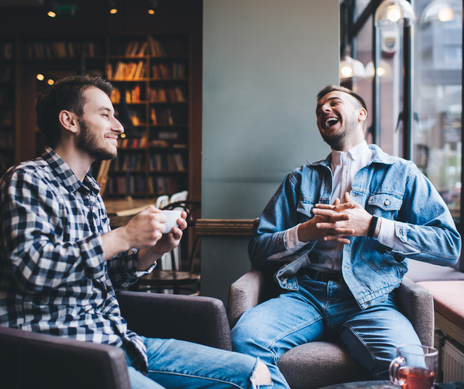 Two men laughing in a coffee shop
