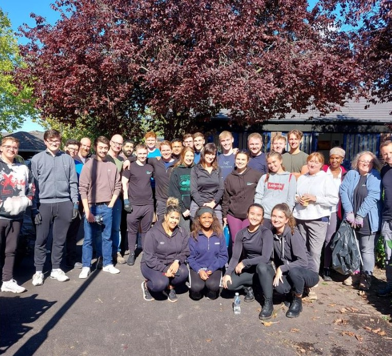 A picture containing volunteers standing in a garden. 