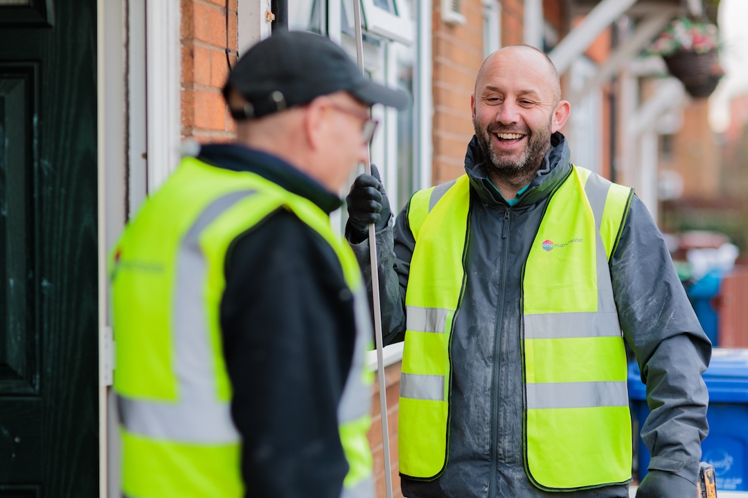Two One Manchester repair operatives, stood outside a property in the Manchester area discussing a repair they are currently working on. 