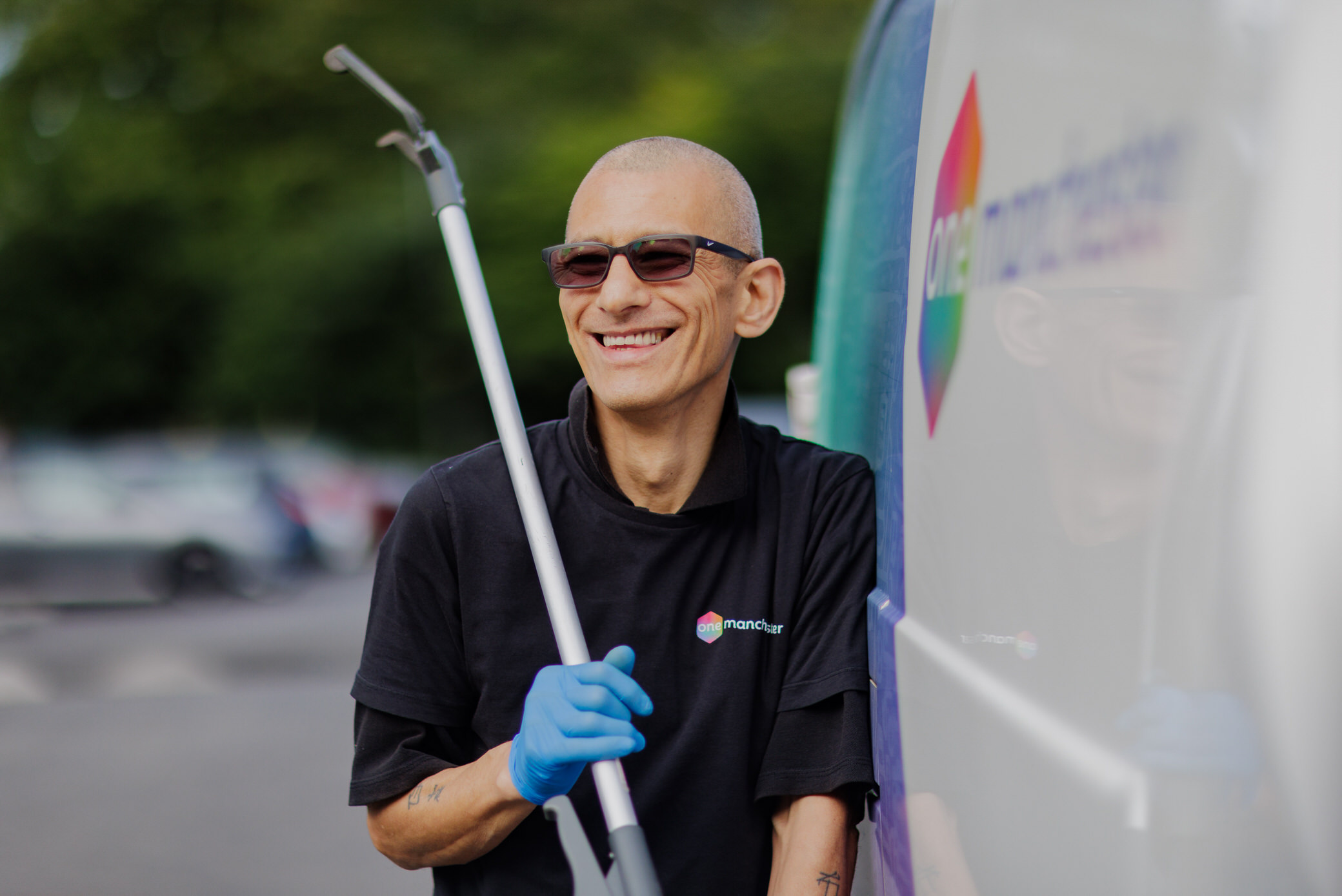 One Manchester colleague holding a litter picker next to One Manchester van