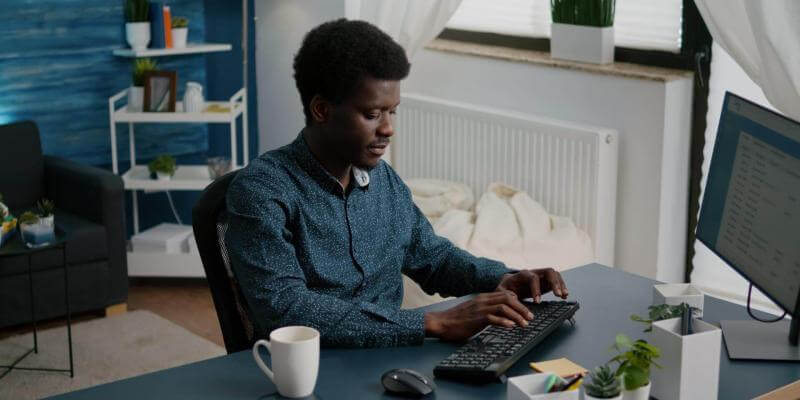 Photo of a man using a computer in his home