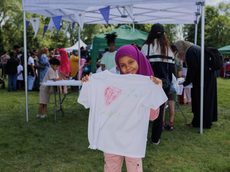 a girl holding up a t-shirt with a heart drawn on it