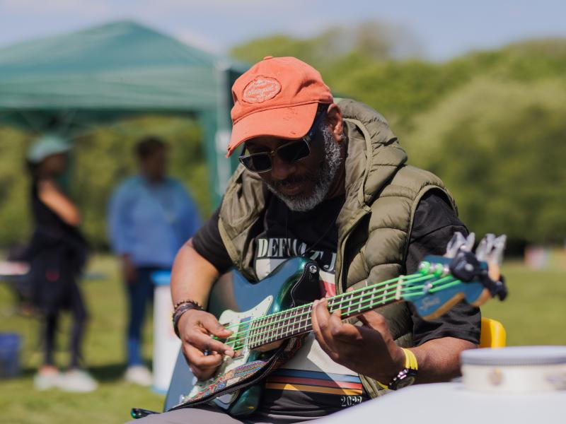 a man plays guitar at a summer event