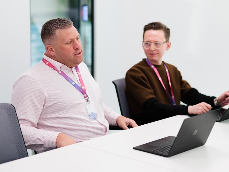 Two colleagues talking at a desk