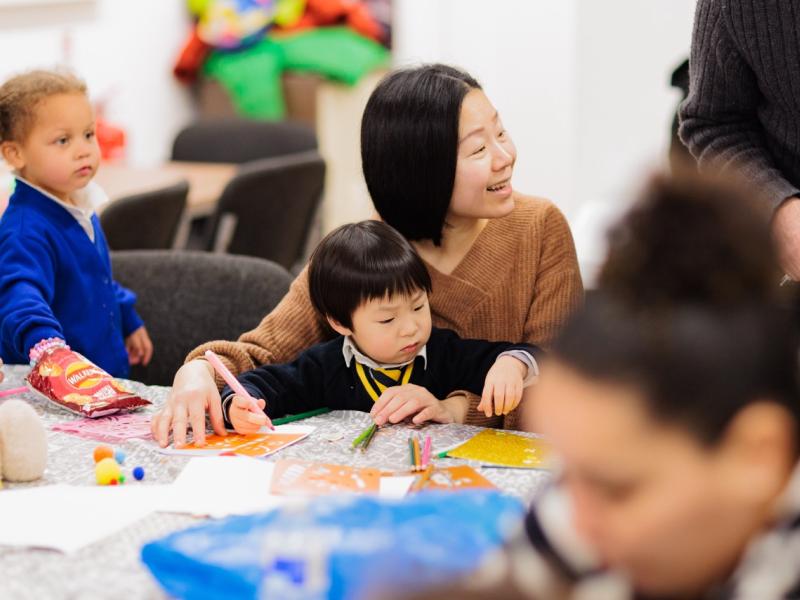 A mother and child doing crafts together at a local community event in Fallowfield