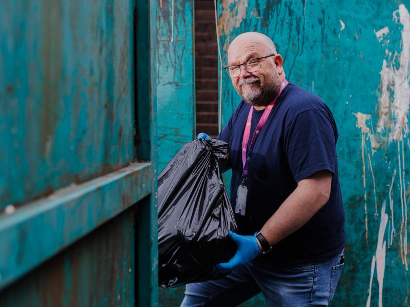 Customer holidng a rubbish bag at a clean up