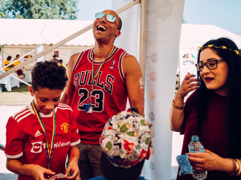 Two people having a conversation with a young person in the picture, wearing a Man united top.