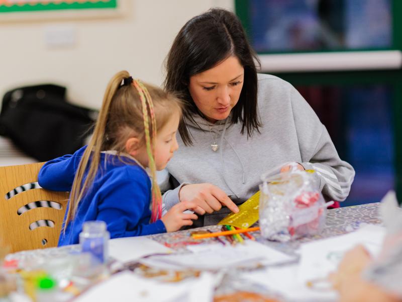 Young child with adult doing crafts