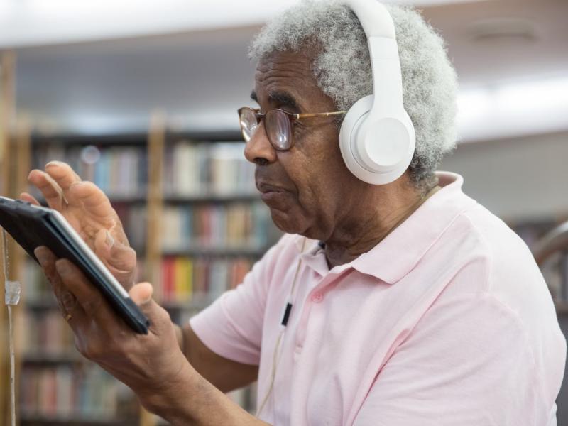 Person wearing headphones using a tablet