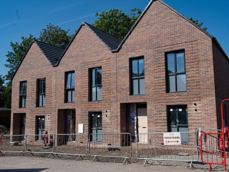 A picture containing a construction site with 3 houses being built in Moston.