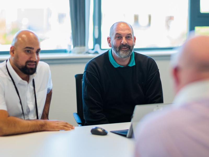 An image of colleagues talking in a meeting