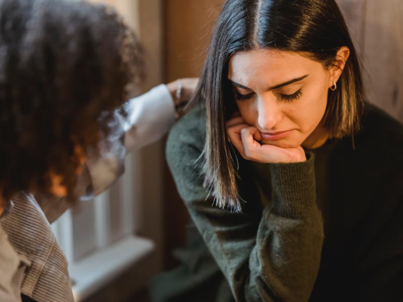 A woman colleague comforting a woman customer