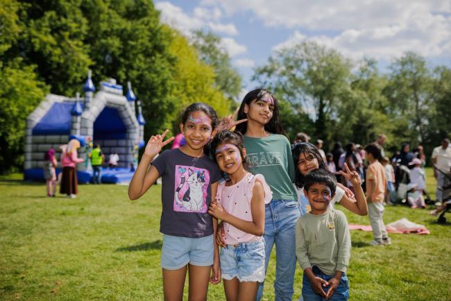 a group of children in facepaint posing for a photo