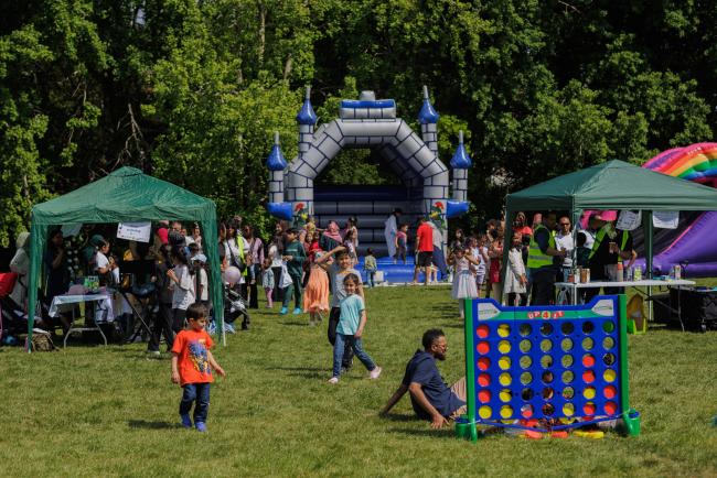 a landscape photo of a summer event with bouncy castle and activity stalls