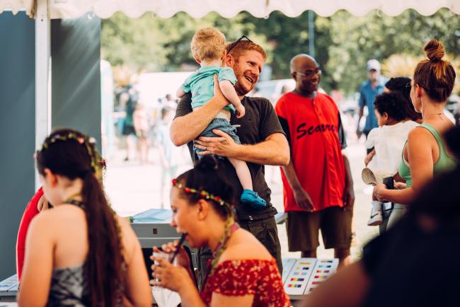 An image of a customer holding a child at a community event