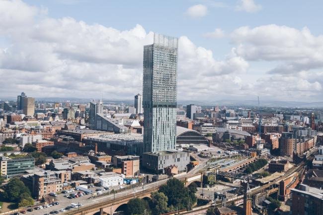 A picture containing a view of Manchester Skyline in the Summer