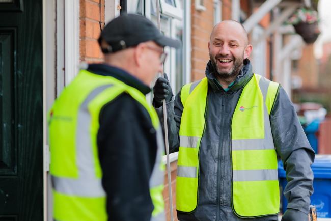 Two One Manchester repair operatives, stood outside a property in the Manchester area discussing a repair they are currently working on. 