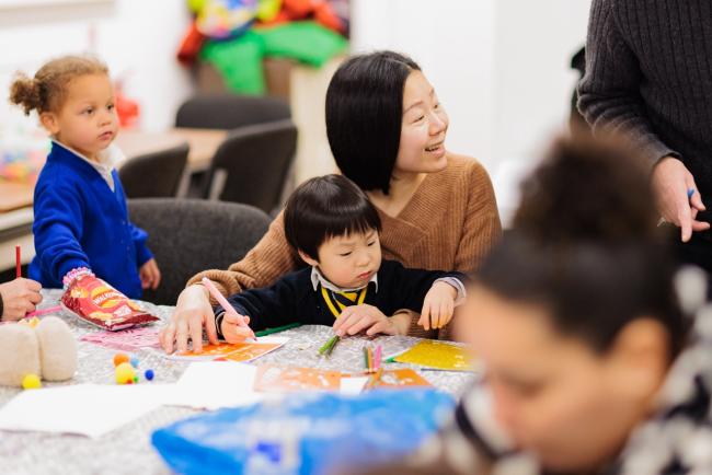 A mother and child doing crafts together at a local community event in Fallowfield