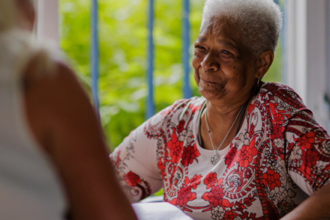 One Manchester Customer smiling, wearing a red dress. 