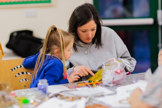 Young child with adult doing crafts