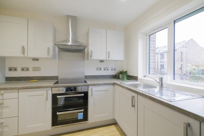 A brand new kitchen in an L shape with a window on to the garden. 