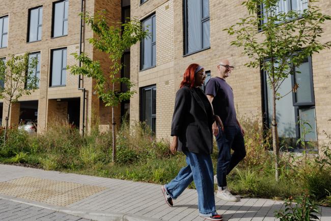 Two people walking under a new development. 