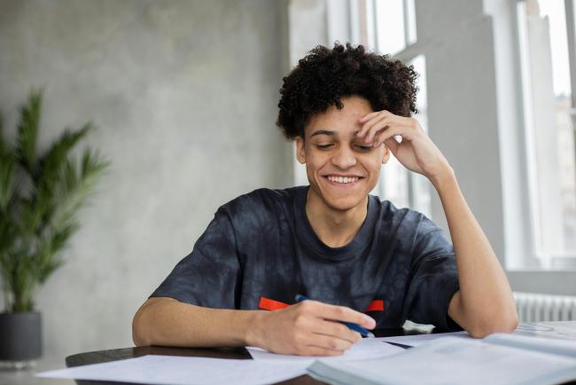 A young person smiling whilst working