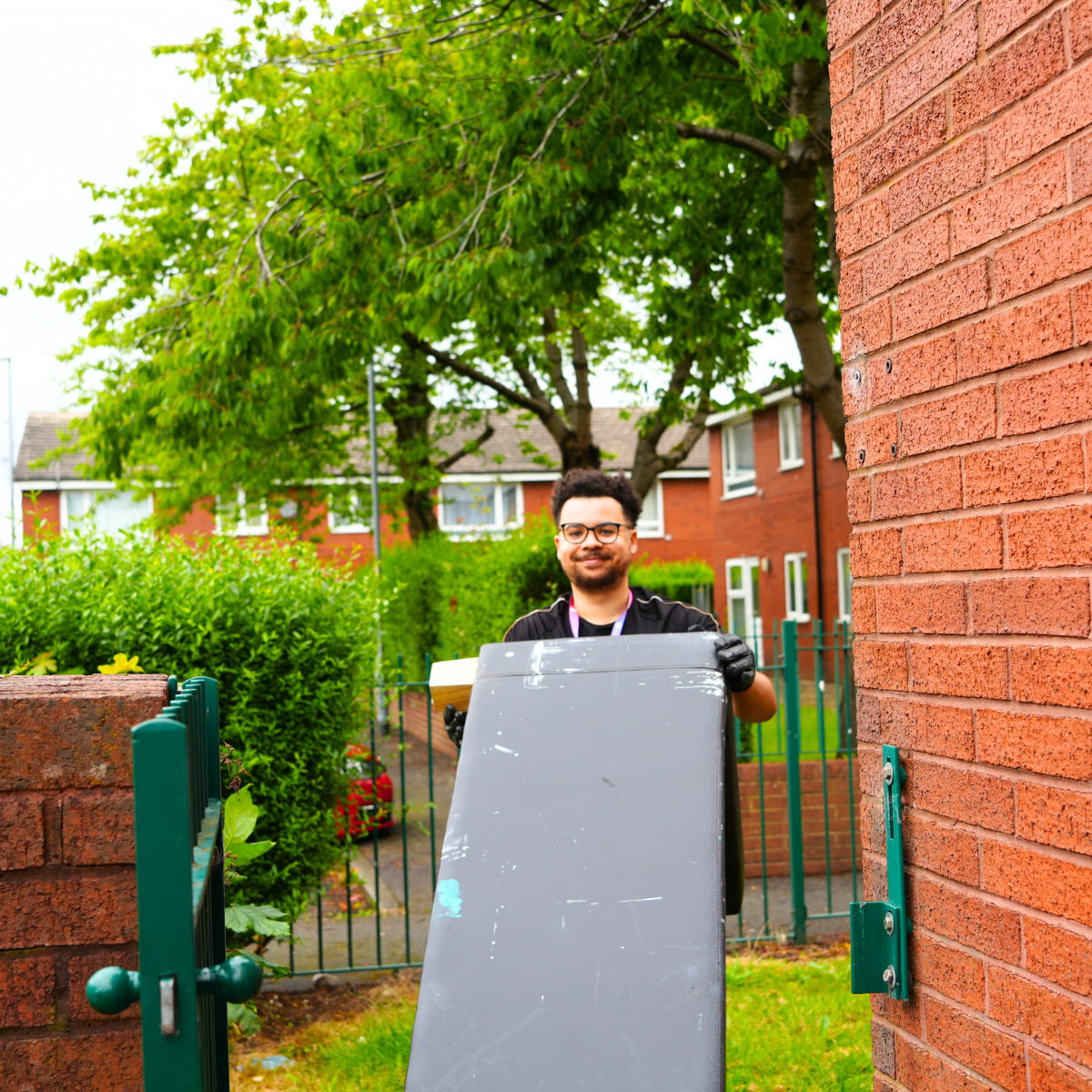 Man carrying old sofa to tip